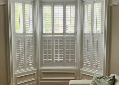 White window shutters for bay windows, tier on tier plantation shutters