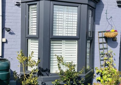 Bay window shutters in in pure white with offset tilt rods. Supplied and installed by Signature Window Shutters Newcastle upon Tyne, North East England