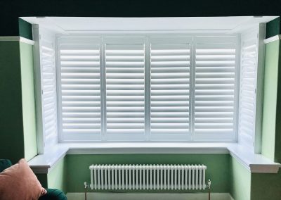 Hardwood Bay window shutters in pure white, easy tilt. Supplied and installed by Signature Window Shutters Newcastle upon Tyne, North East England