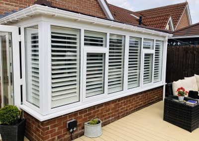 white wooden window shutters on a conservatory in blaydon, tyne and wear. Supplied and fitted by Signature Window Shutters Newcastle